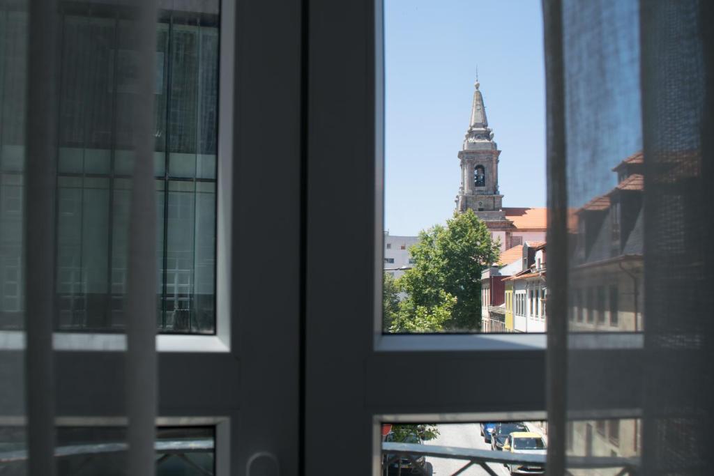 a view from a window of a building with a clock tower at Goodgarden Downtown Apartment in Porto