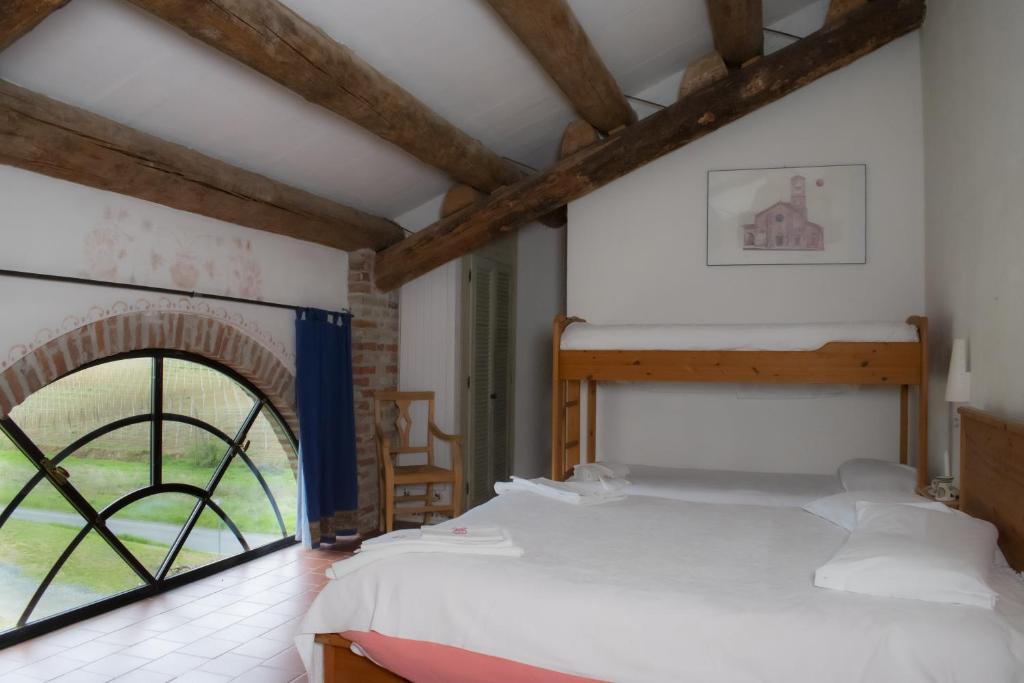 um quarto com uma cama e uma grande janela em Agriturismo Il Buonvicino em Cassine