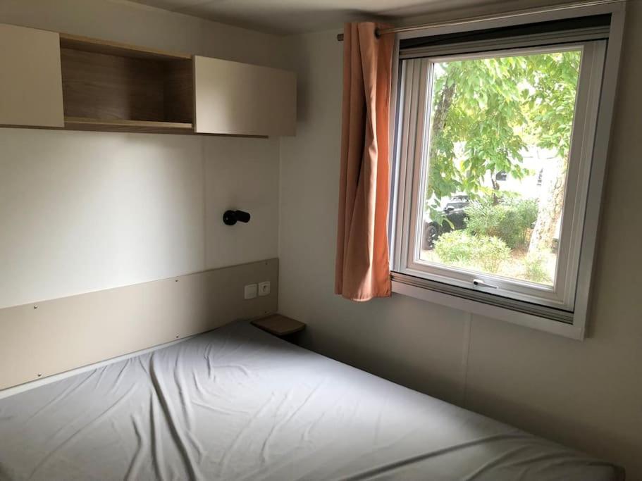 1 dormitorio con cama y ventana en Mobilhome 6 personnes Cap Ferret, en Lège-Cap-Ferret