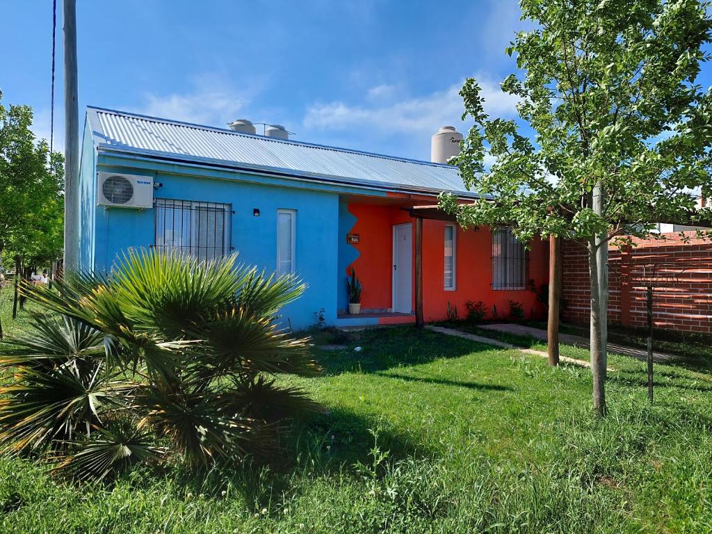 una casa azul y roja con un árbol en el patio en Departamentos Lathine en San José
