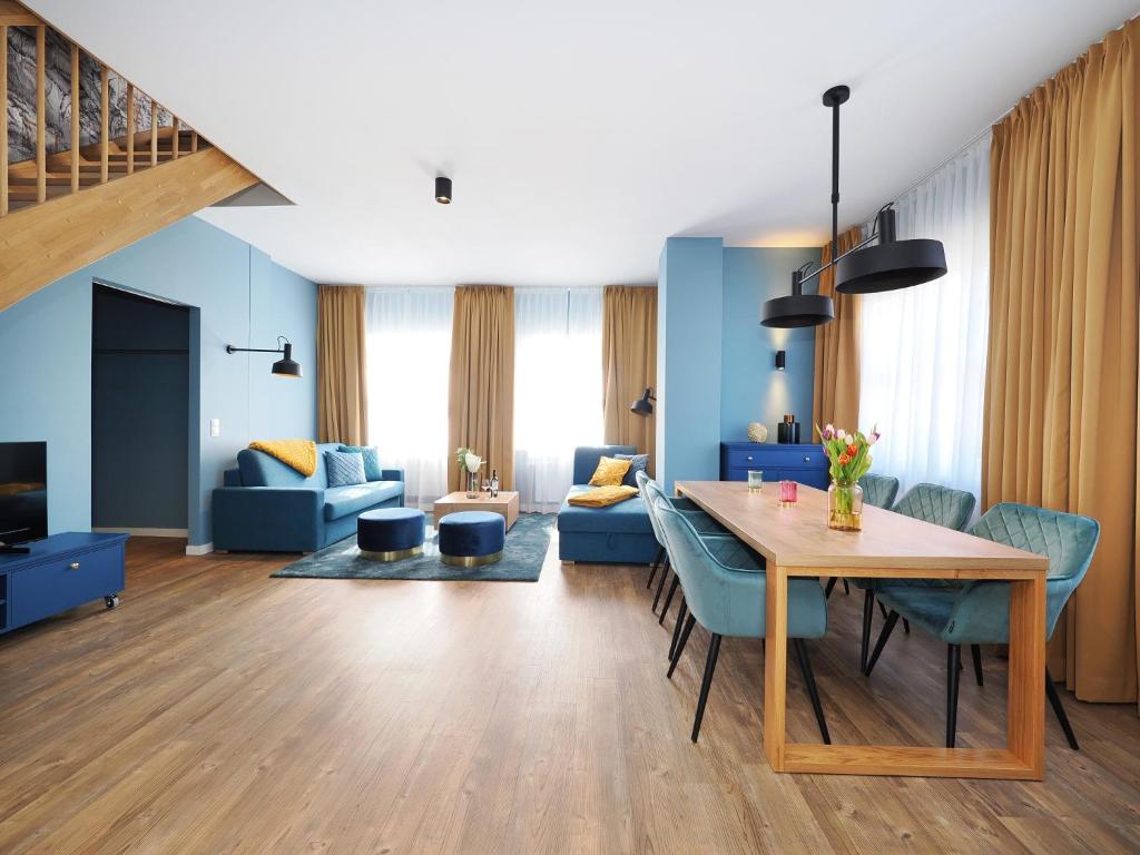 un soggiorno con tavolo e sedie blu di Seebrücke Heringsdorf - Appartement mit 2 Schlafzimmern und Terrasse S17 a Heringsdorf