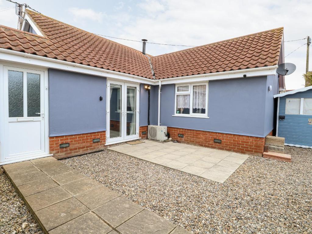 a blue house with a driveway in front of it at Kingfisher Lodge in Great Yarmouth