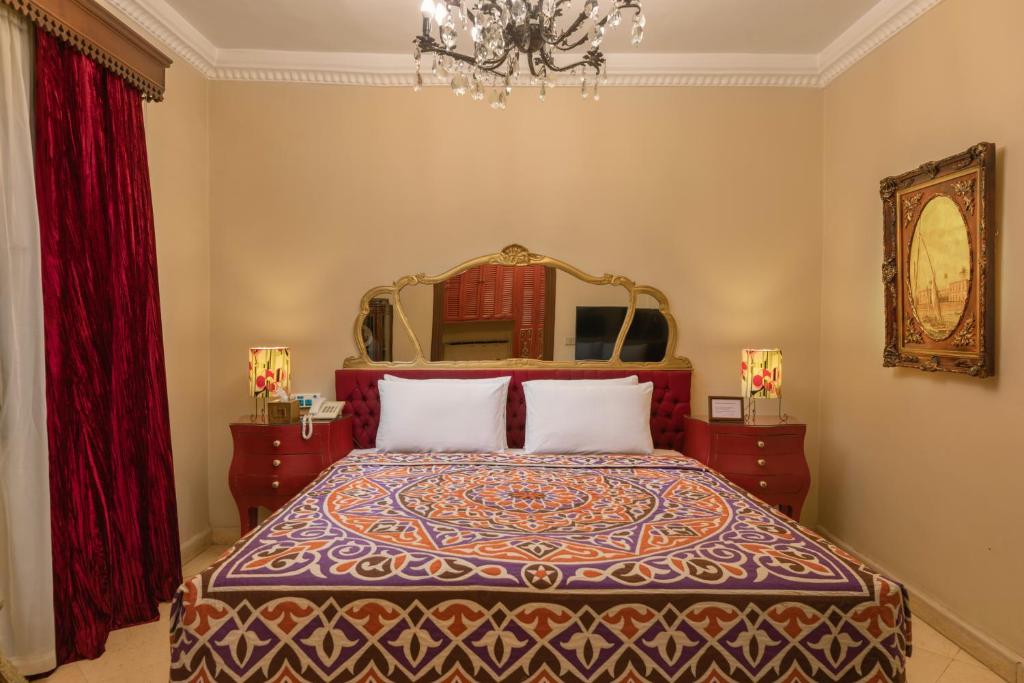 a bedroom with a bed with a large mirror at Le Riad Hotel de Charme in Cairo
