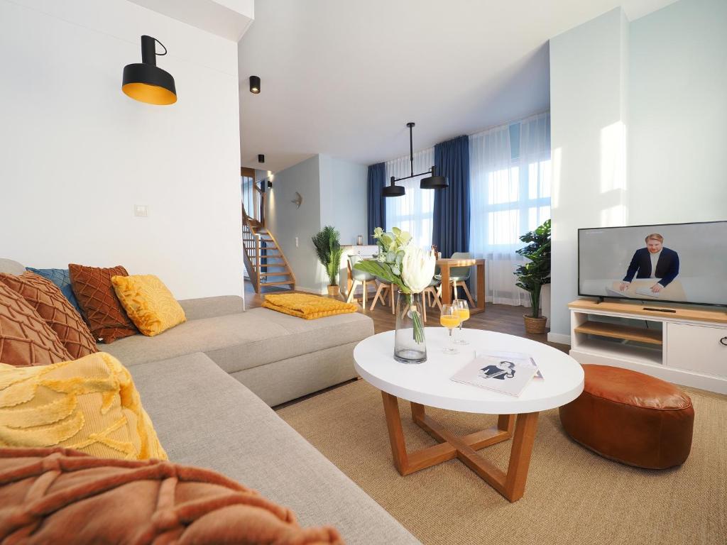 un soggiorno con divano e TV di Seebrücke Heringsdorf - Appartement mit 2 Schlafzimmern und Terrasse S21 a Heringsdorf