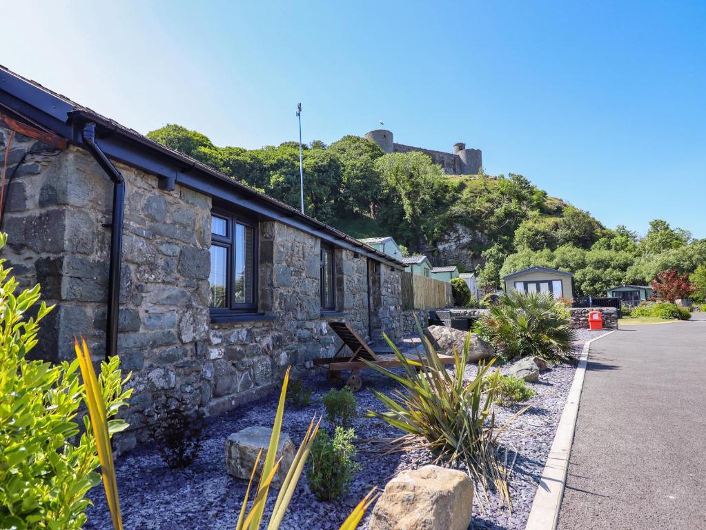 a stone building with plants in front of it at Tan Llech in Harlech