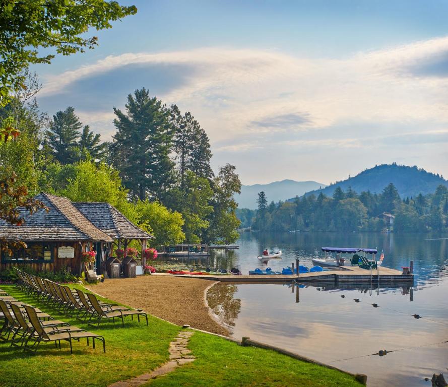 a lake with a dock and boats on the water at Mirror Lake Inn Resort and Spa in Lake Placid