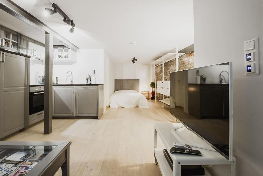 a large white room with a bed and a kitchen at Central studio basement apartment in Bergen