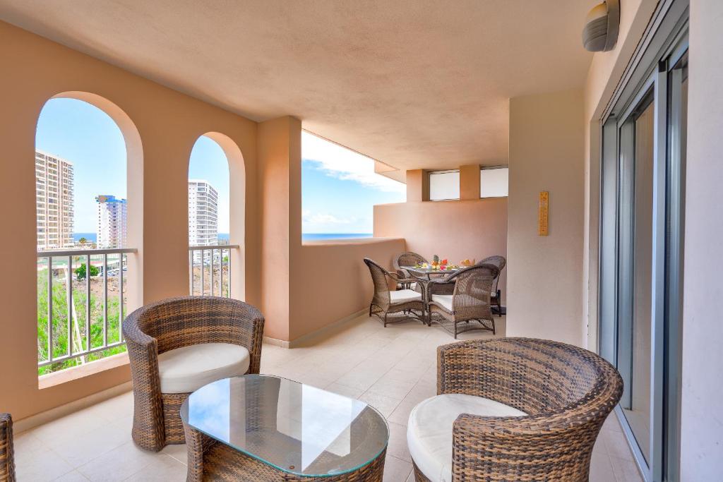 a living room with chairs and a table and windows at Gina s Sun Terrace in Playa Paraiso