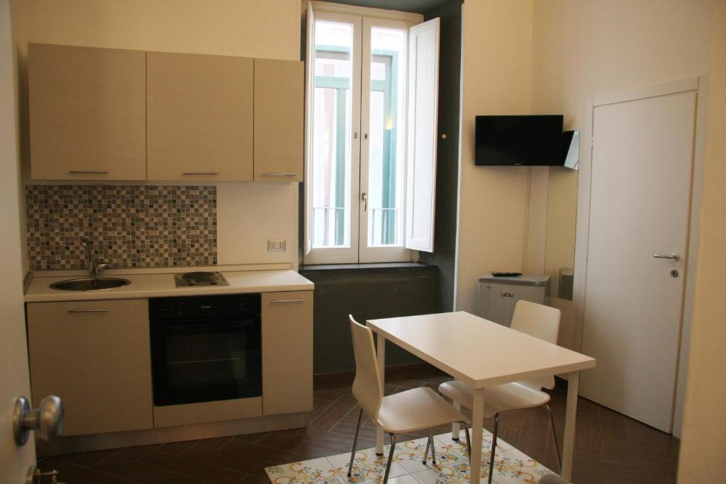 a kitchen with a table and a table and chairs at Palazzo della Poesia Casa Vacanze in Salerno