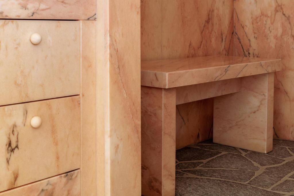 a wooden cabinet with a bench next to a cupboard at Cap d'Antibes Beach Hotel in Juan-les-Pins