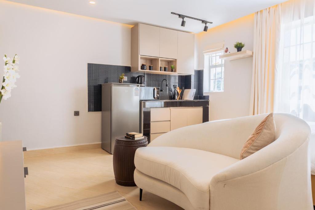 奈瓦沙的住宿－Luxe Studio and 1 bedroom Apartment，一间带白色沙发的客厅和一间厨房