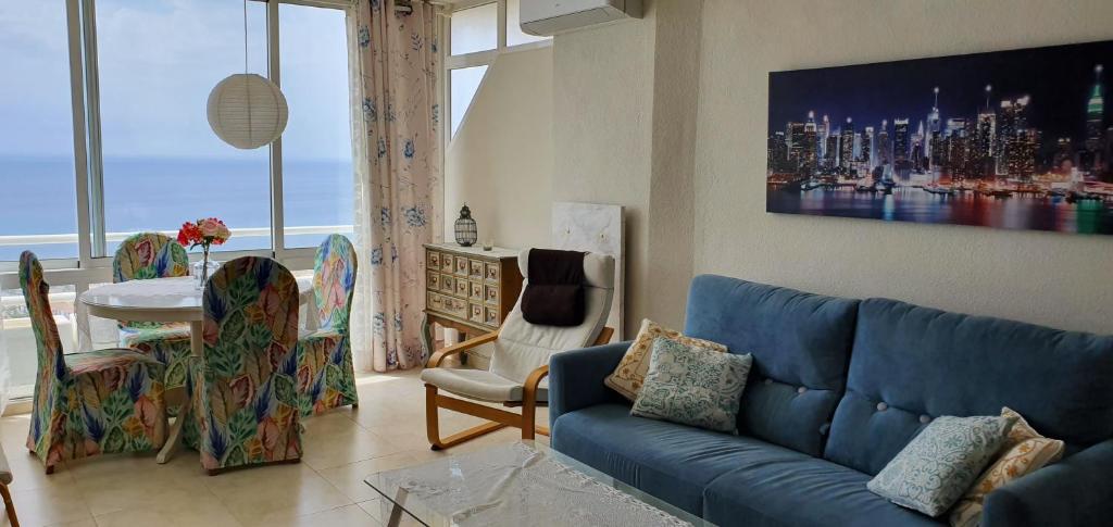 un soggiorno con divano blu e tavolo di Sea View Penthouse Duplex near Beach a Mijas Costa