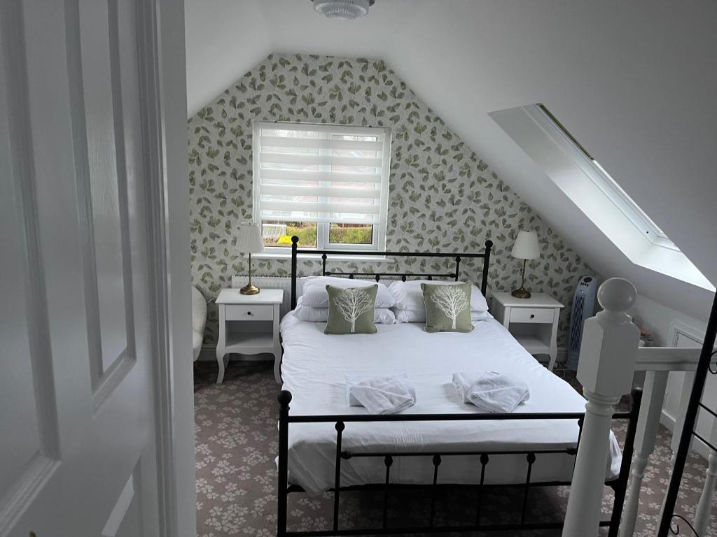 a bedroom with a bed and a staircase with a window at Penny Farthing Hotel & Cottages in Lyndhurst