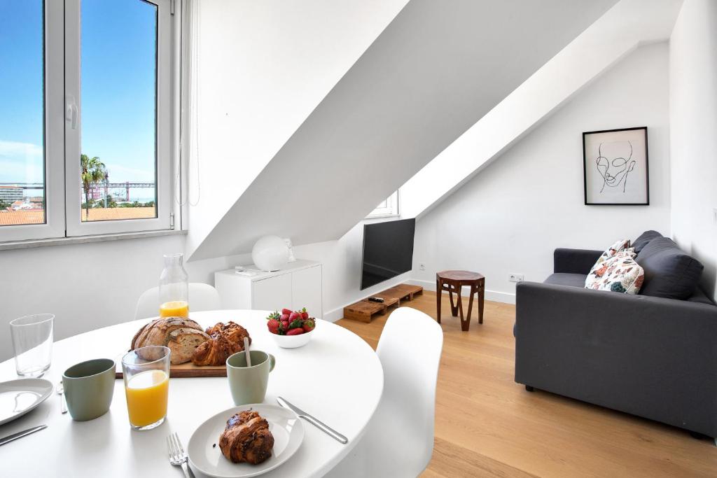 uma sala de estar branca com uma mesa e um sofá em Brand New River View Apartment Belém - 1 bedroom, A/C em Lisboa