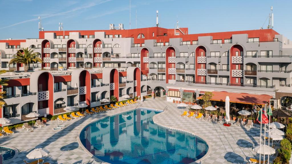 um hotel com piscina em frente a um edifício em Muthu Oura Praia Hotel em Albufeira