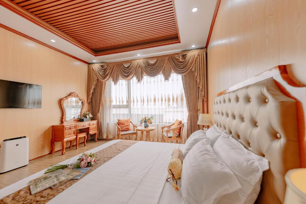 een slaapkamer met een groot bed en een bureau bij Tuan Nam Hotel in Hai Phong