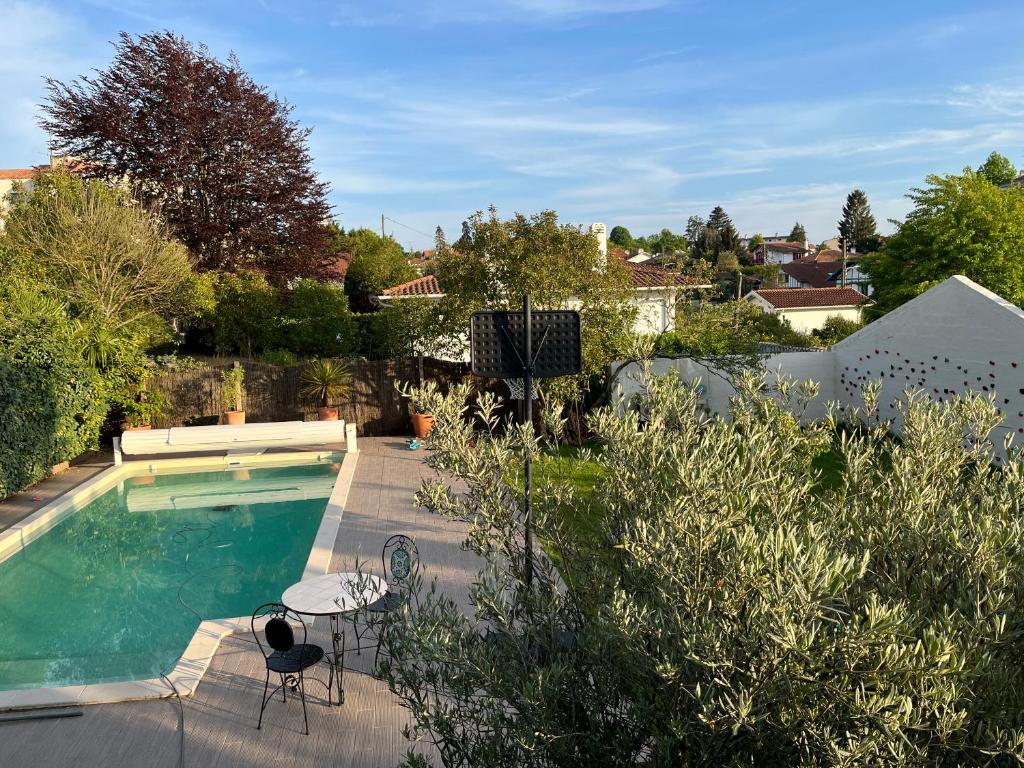 a swimming pool with two chairs and a table in a yard at Belle maison familiale Basque in Bayonne