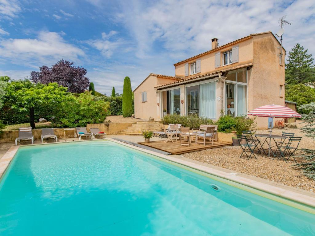 a villa with a swimming pool in front of a house at Holiday Home Les Iris by Interhome in Gargas