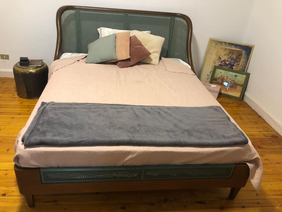 1 cama con cabecero verde y almohadas en Spacious downtown Nile apartment, en El Cairo