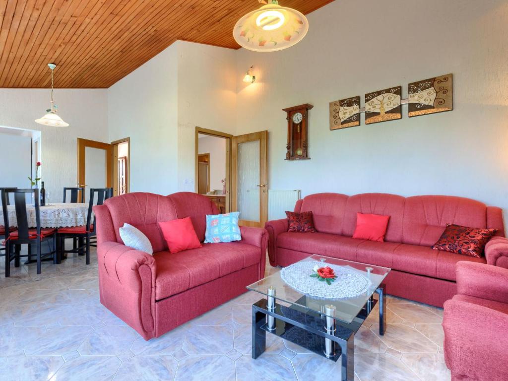 salon z 2 czerwonymi kanapami i stołem w obiekcie Apartment Ana-2 by Interhome w mieście Jehnići