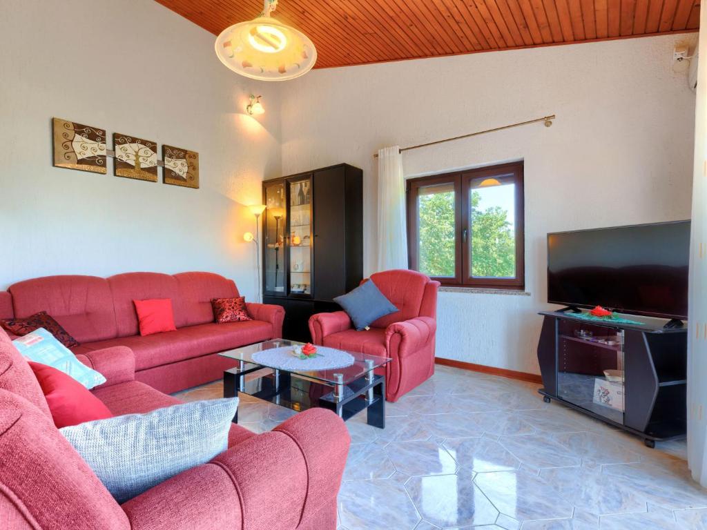 salon z czerwonymi kanapami i telewizorem z płaskim ekranem w obiekcie Apartment Ana-2 by Interhome w mieście Jehnići