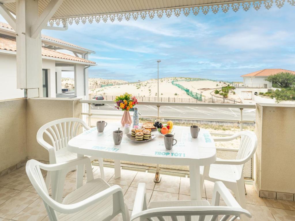 ミミザン・プラージュにあるApartment Patguyflor by Interhomeの白いテーブルと椅子、景色を望むバルコニー