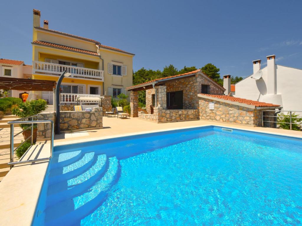 a swimming pool in front of a villa at Holiday Home Cici by Interhome in Iž Mali