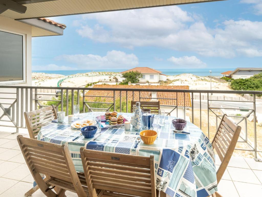 a table on a balcony with a view of the ocean at Apartment Côte Sud-4 by Interhome in Mimizan-Plage