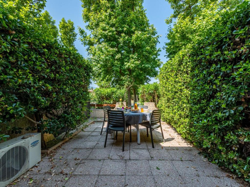 a table and chairs in the middle of a hedge at Holiday Home Le Lagon by Interhome in Saint-Cyprien-Plage