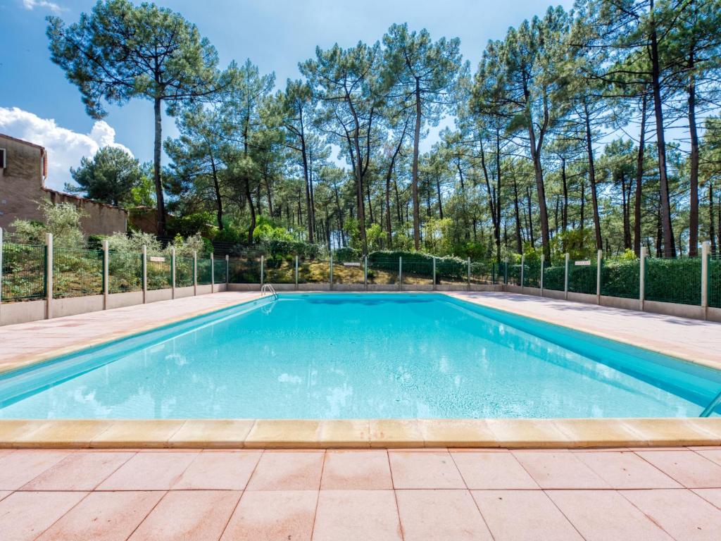 a swimming pool with a tile floor and a fence at Holiday Home Les Palombes-3 by Interhome in Lacanau-Océan