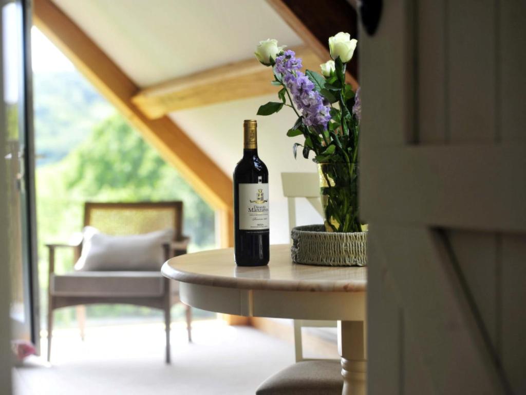 PonsanoothにあるStudio The Cottage by Interhomeの花瓶を置いたテーブルに座ったワイン1本