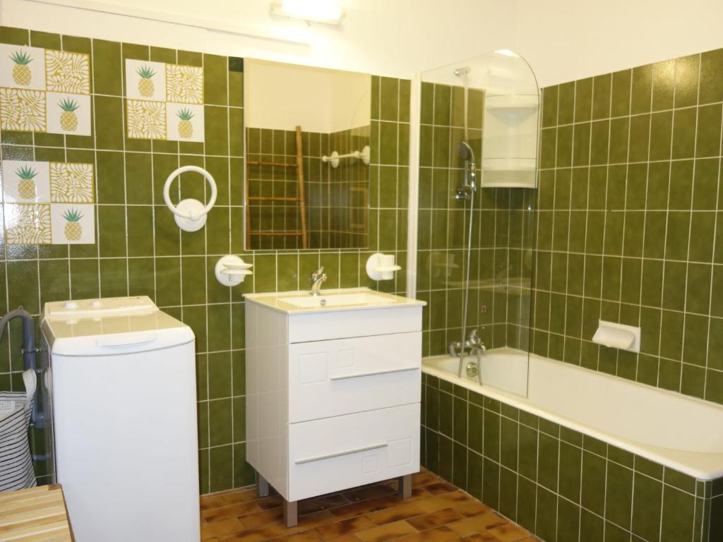 a green tiled bathroom with a sink and a tub at Apartment Hameau la Madrague-22 by Interhome in La Madrague