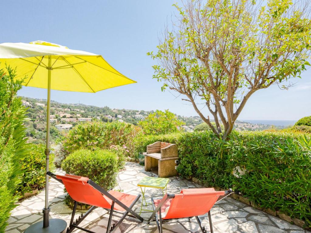 a patio with two chairs and an umbrella at Apartment Les Hauts des Issambres-11 by Interhome in Les Issambres