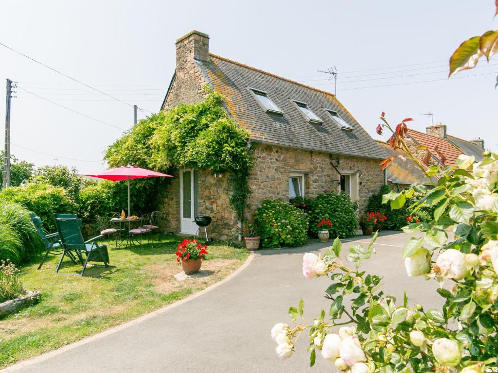une maison en pierre avec une table, des chaises et un parasol dans l'établissement Holiday Home L'Hirondelle by Interhome, à Kermerchou