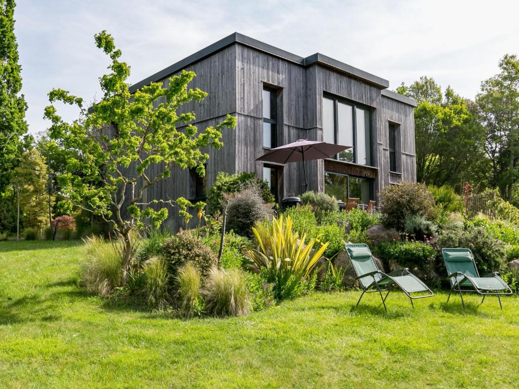 une maison avec un jardin et deux chaises en face dans l'établissement Chalet Ty Coat - LFF107 by Interhome, à La Forêt-Fouesnant