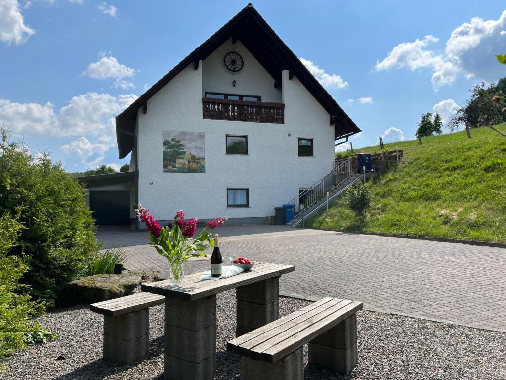 ein Gebäude mit einem Tisch und einem Gebäude mit einer Uhr in der Unterkunft Apartment Hartmann by Interhome in Laudenau