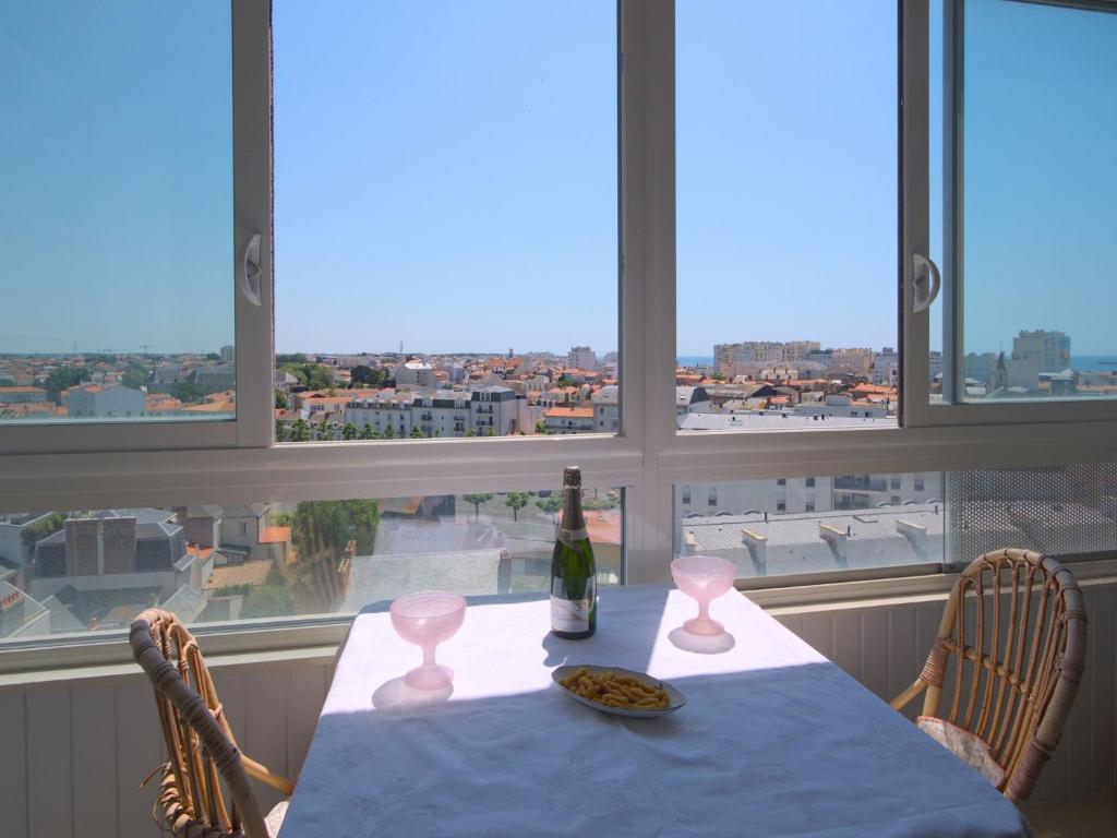 - une table avec une bouteille de vin et une assiette de nourriture dans l'établissement Apartment L'Escale Vendée Globe - LSD300 by Interhome, à Les Sables-dʼOlonne