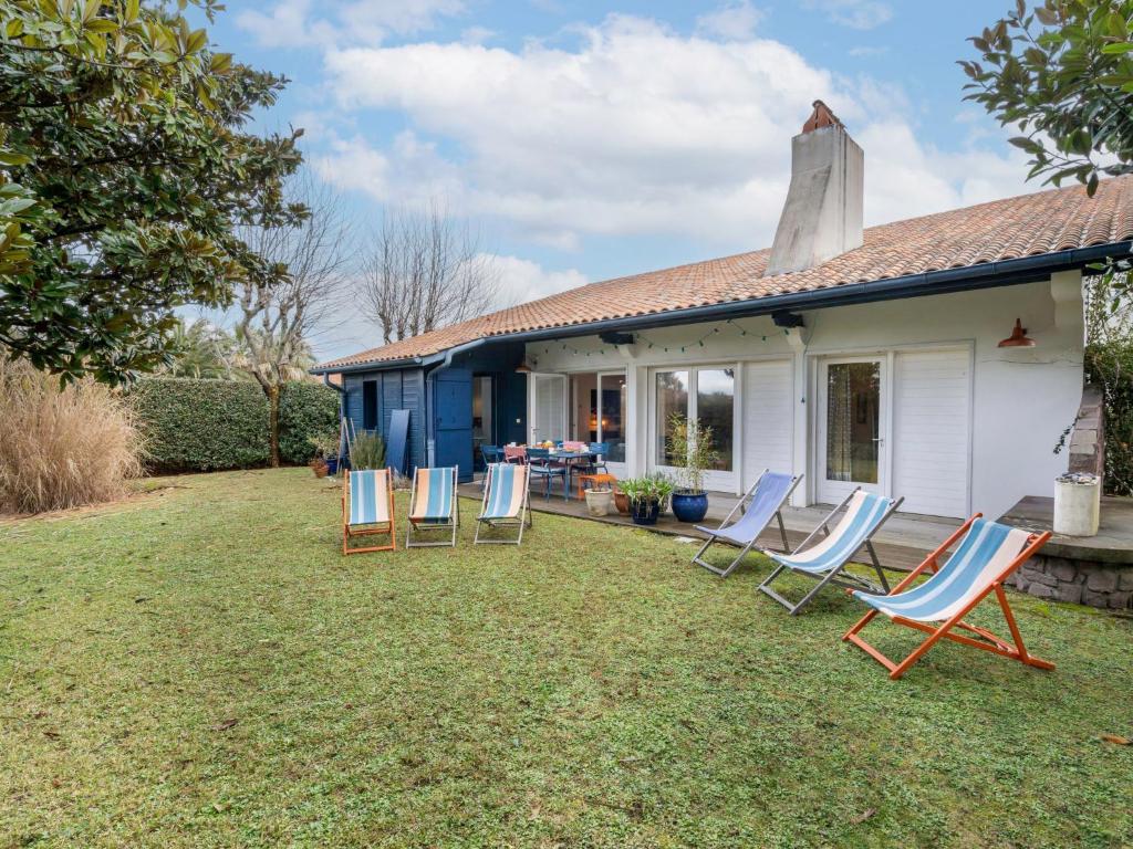 a group of chairs sitting in the yard of a house at Holiday Home Maison Bleue by Interhome in Saint-Jean-de-Luz