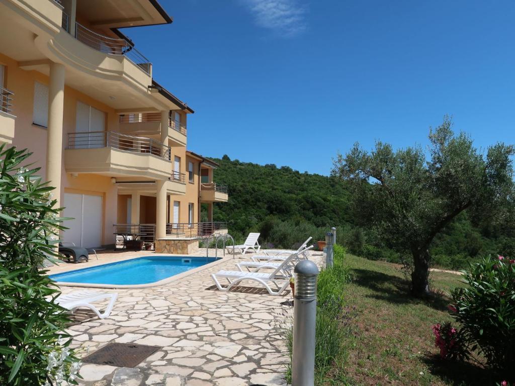 a villa with a swimming pool and a house at Apartment Magnolia - RAC167 by Interhome in Rabac