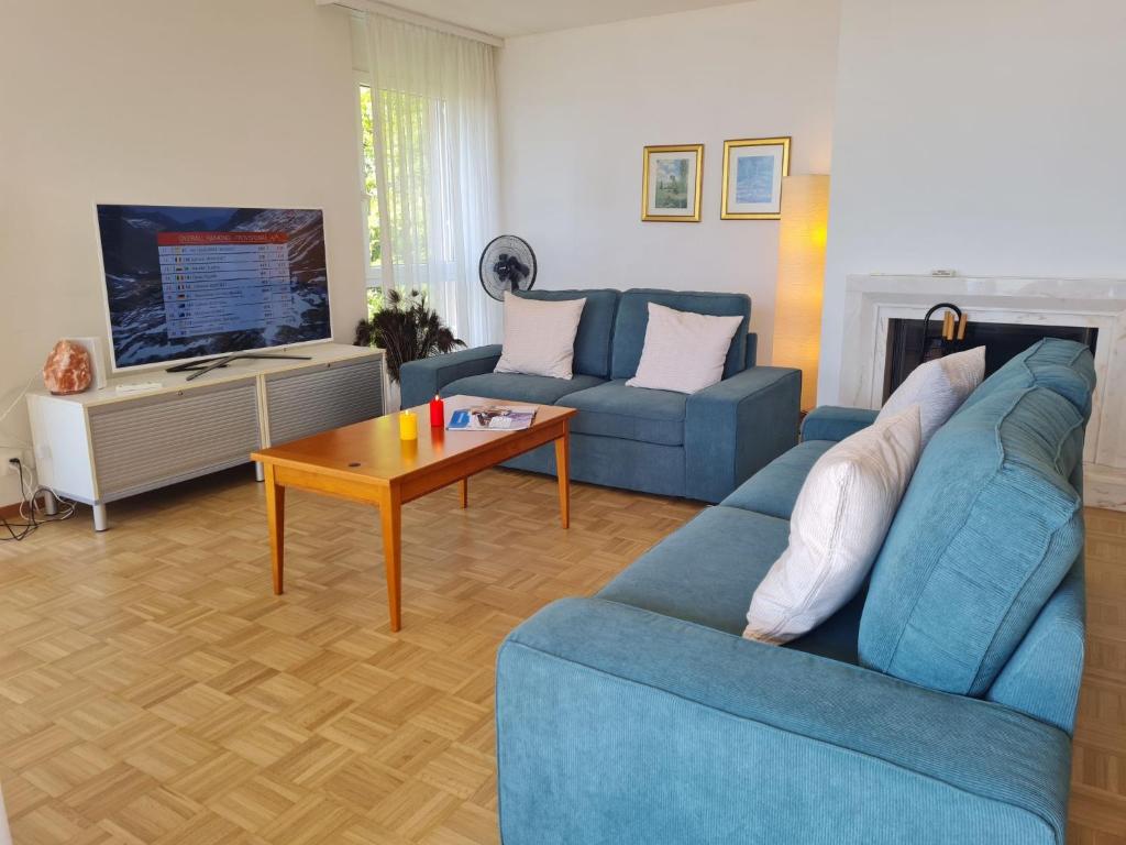 a living room with a blue couch and a table at Apartment Montreux - Panorama by Interhome in Montreux