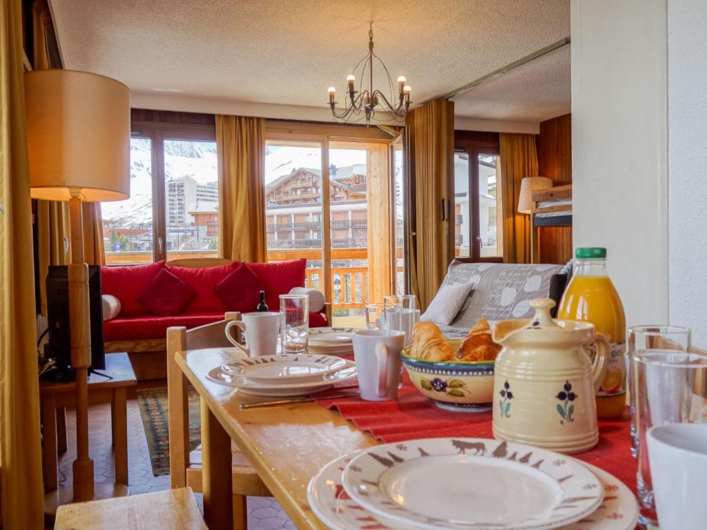 a dining room table with plates of food on it at Apartment Les Grandes Balmes I et II - Le Lac-9 by Interhome in Tignes