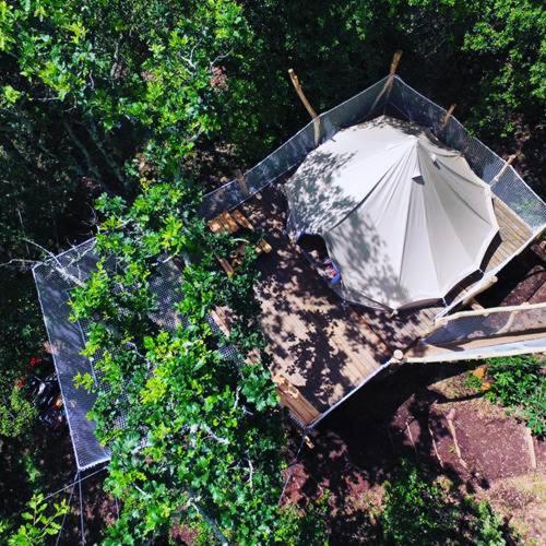 - une vue sur le jardin avec un parasol blanc dans l'établissement TENTE HIBOU INSOLITE AVEC FILET DE DETENTE Camping lou cantou cevenol, à Anduze