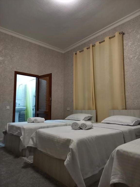ein Zimmer mit 2 Betten und Handtüchern darauf in der Unterkunft Guest house Zebiniso in Samarkand