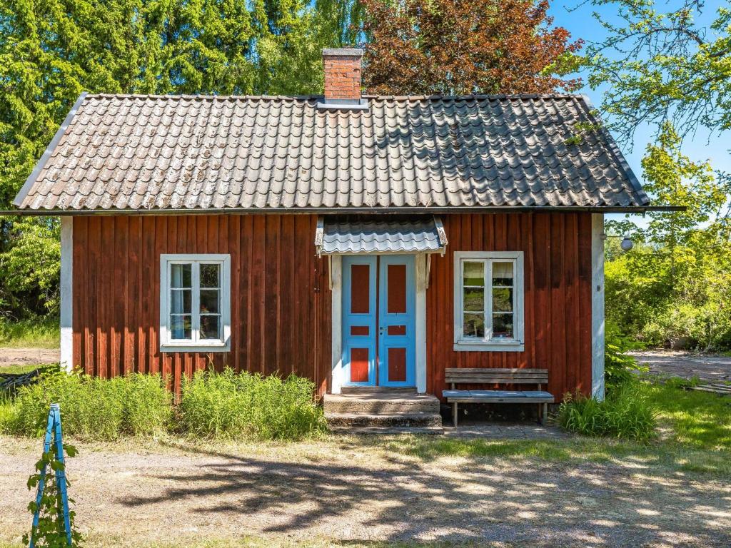 une petite maison rouge avec une porte bleue dans l'établissement Holiday Home Ebbabolet by Interhome, à Tibro