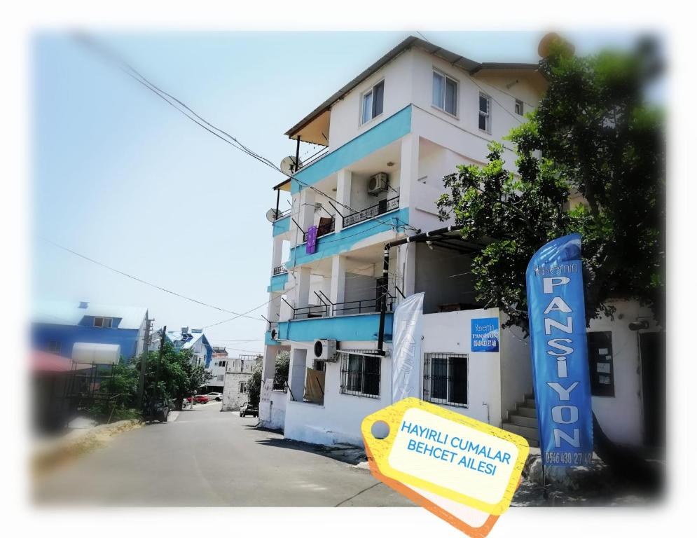 a building with a blue sign in front of it at Yasemin Apart in Erdemli