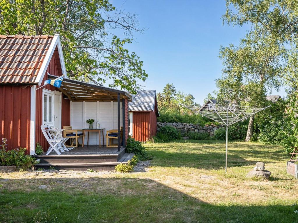 Cabaña roja y blanca con mesa en el patio en Holiday Home Bergkvara - SND033 by Interhome, en Bergkvara