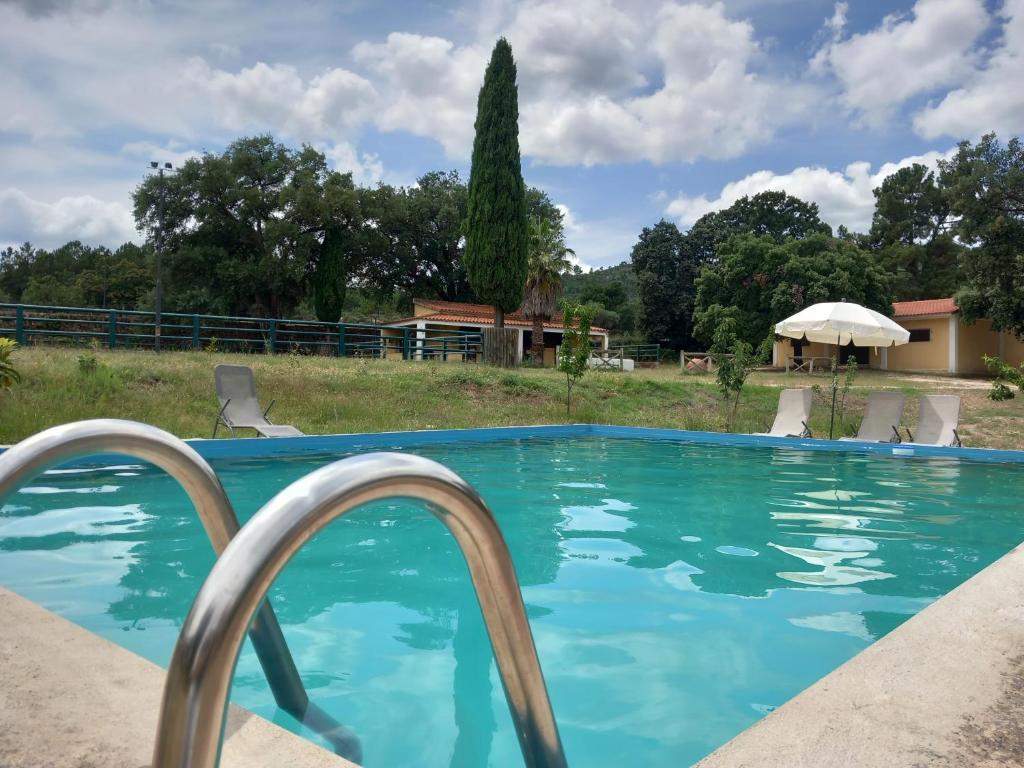 a swimming pool with a house in the background at Casa da Vinha in Castelo Novo