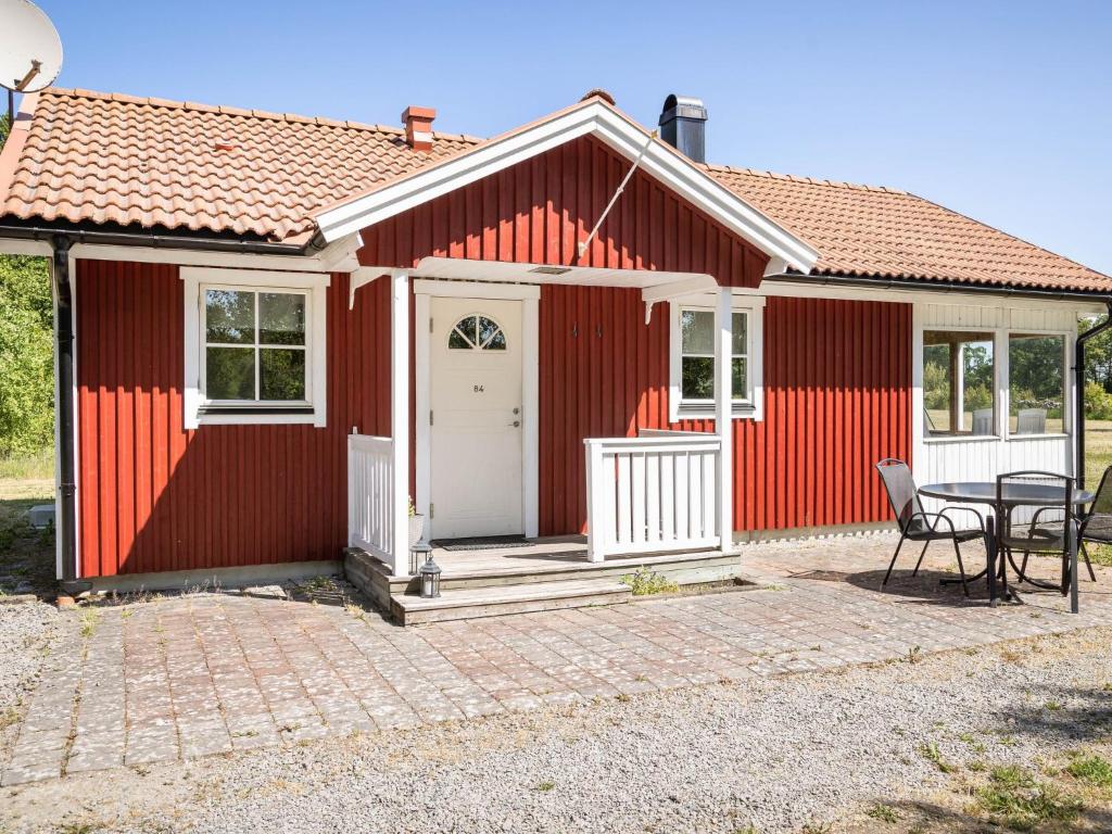 Kalvsvik的住宿－Holiday Home Skärvudde Huset - SND084 by Interhome，前面有一张桌子和椅子的红色房子