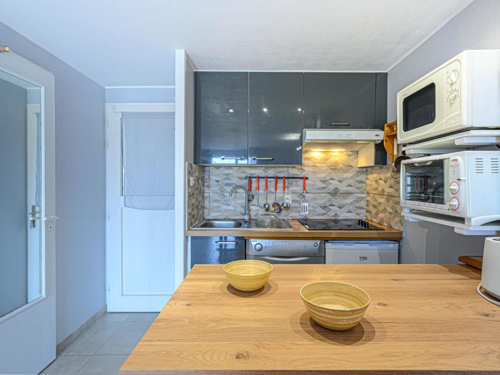 カルナック・プラージュにあるHoliday Home Maison de la Plage by Interhomeのキッチン(木製テーブル、ボウル2つ付)