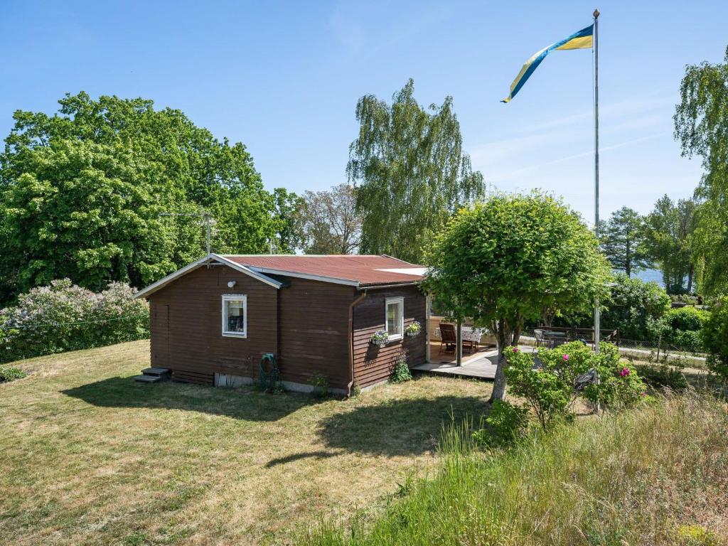 a small house in a yard with a tree at Holiday Home Djursvik - SND029 by Interhome in Söderåkra
